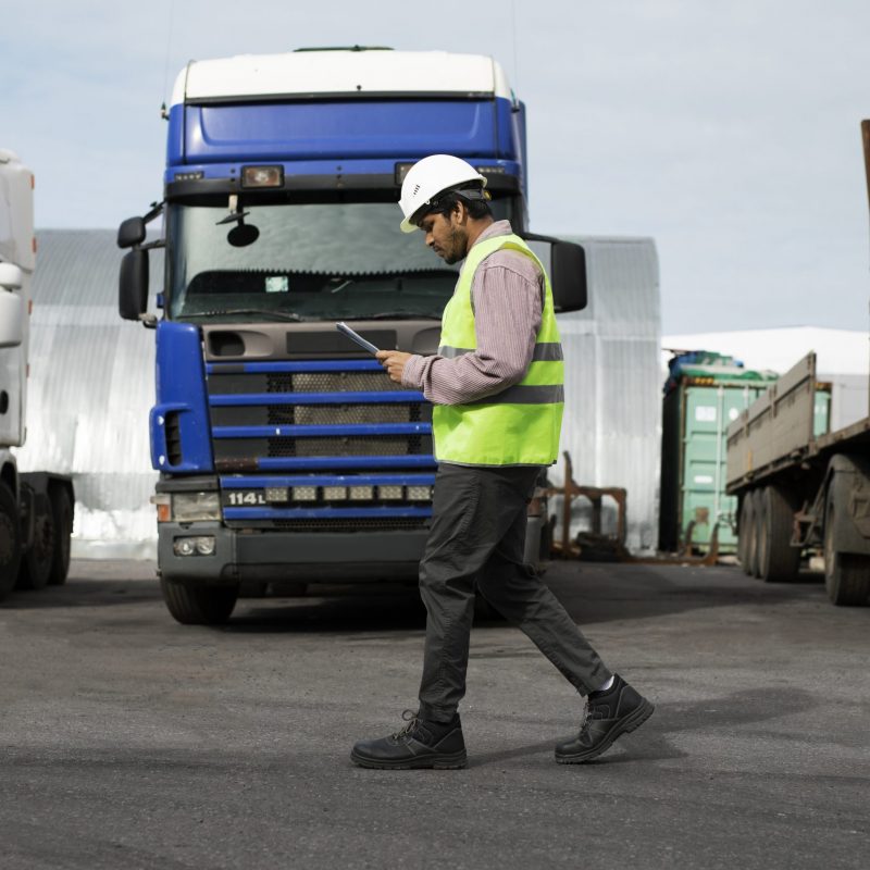 Verkehrsleiter kontrolliert LKW-Flotte auf dem Betriebshof
